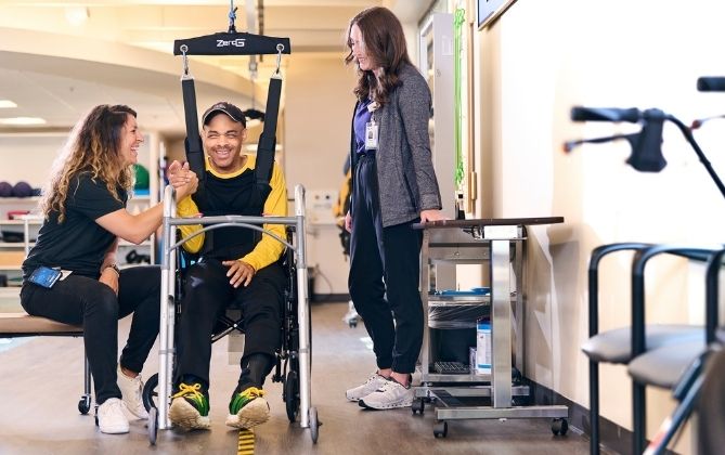 John Davis works with Physical Therapist Taylor Galmarini and Exercise Physiologist Meghan Santander during a physical therapy session using the  ZeroG® Gait and Balance System.